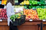 woman shopping for fruits and vegetables at grocery store