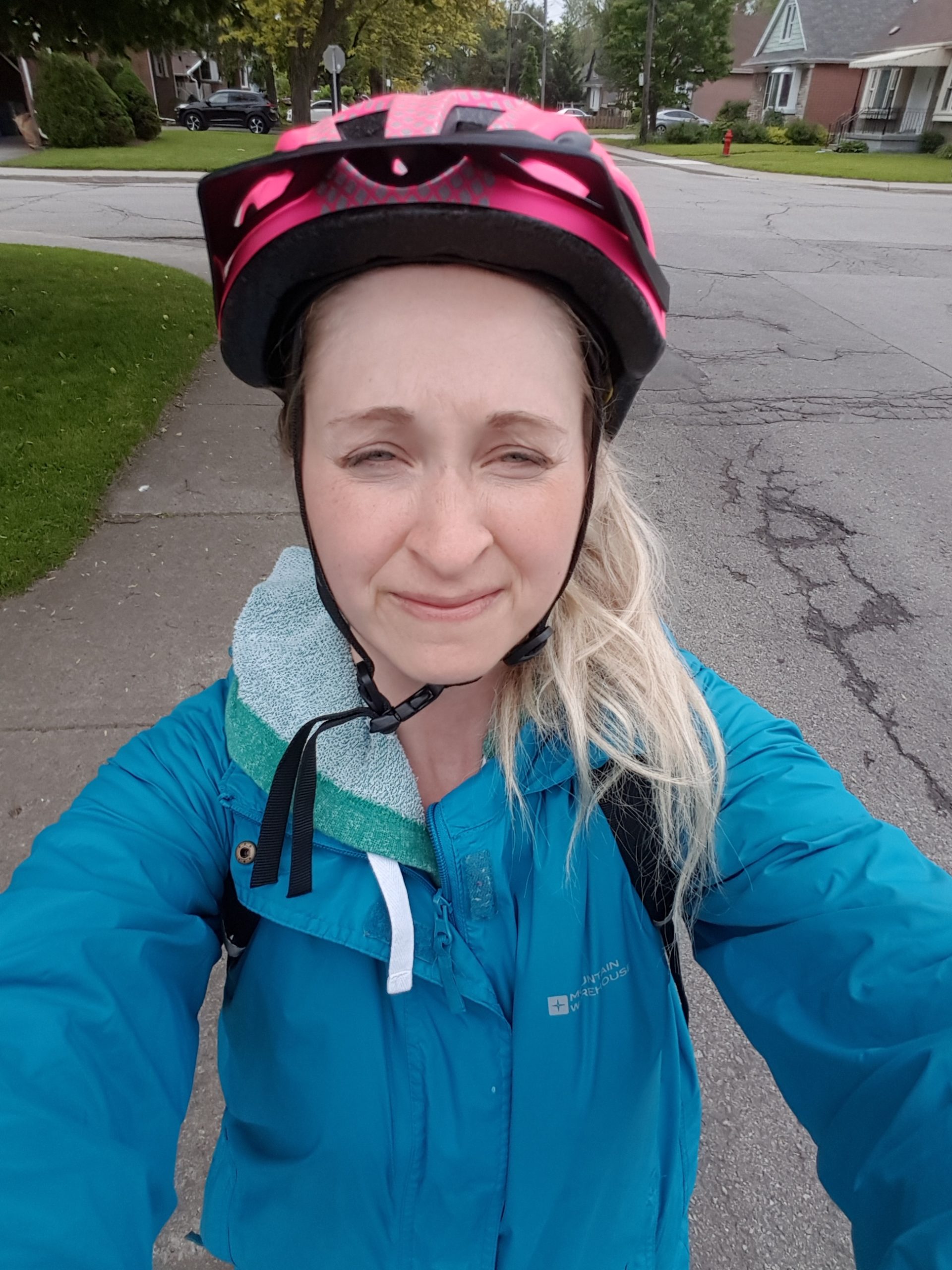 A woman with a blue coat and a bike helmet