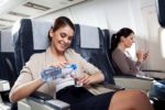 women pouring water in a cup on a plane