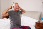 elderly man waking up from bed smiling