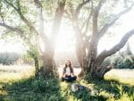 woman meditating between 2 trees