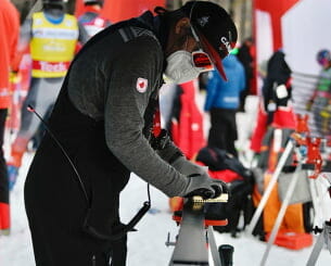 Man sharpening a ski outdoors
